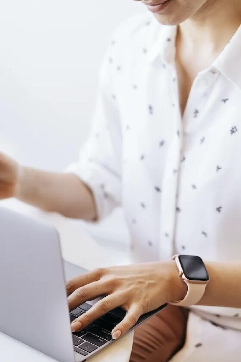 A woman sits at her laptop segmenting her email list to increase conversions.